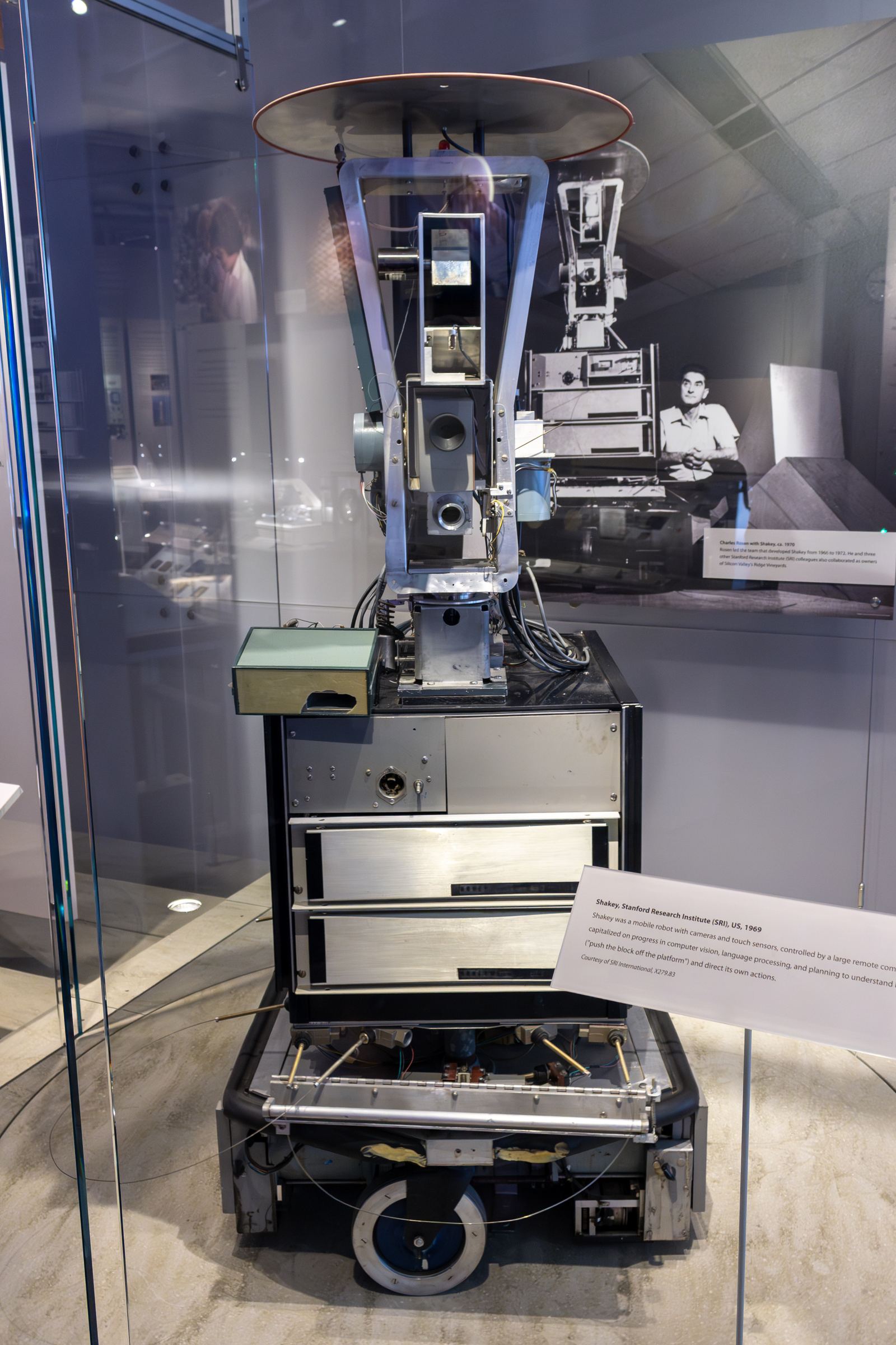 Shakey, a tall wheeled robot with a camera head, on display at the Computer History Museum